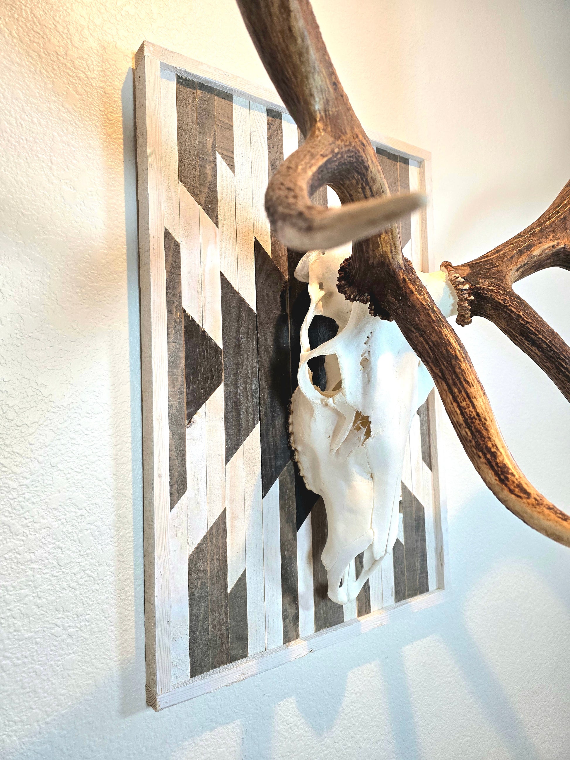 Aztec-inspired euro mount plaque with a geometric pattern, attached to a wall behind a skull trophy.