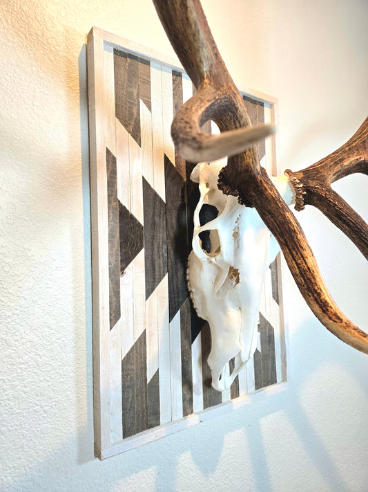 Aztec-inspired euro mount plaque with a geometric pattern, attached to a wall behind a skull trophy.
