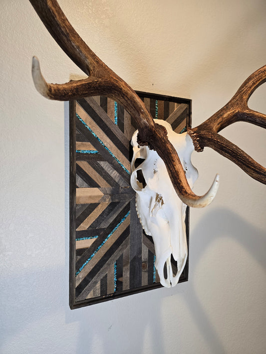 Deer skull and antlers on a decorative wood mosaic with geometric pattern